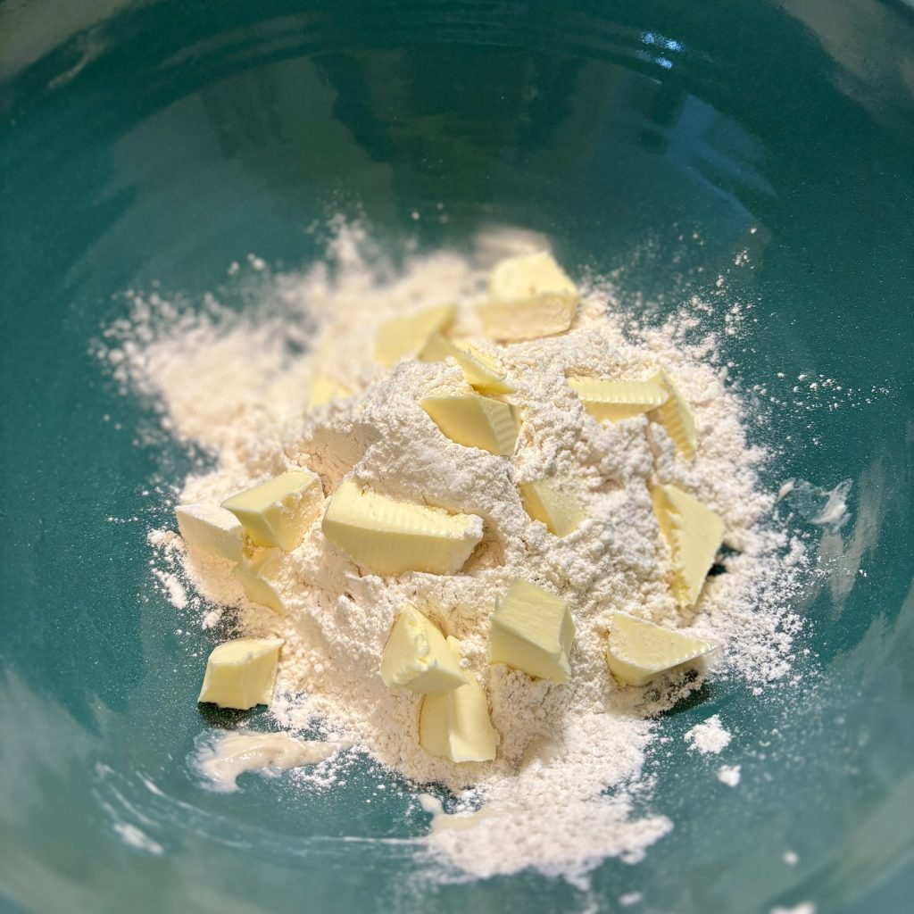 Eine Schüssel mit Mehl und Stücken von Butter, bereit zur Herstellung eines Wähenteigs.