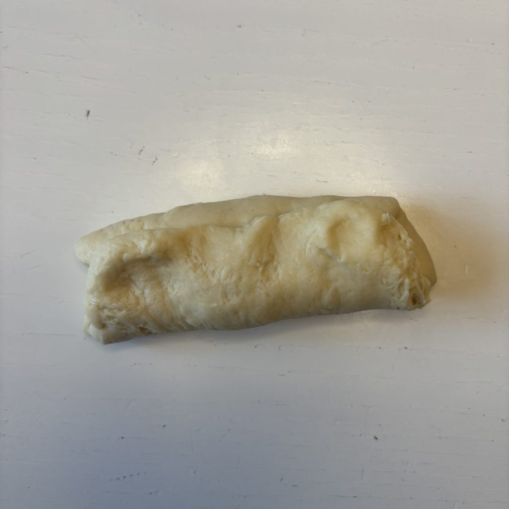 Sauerteig Burger Buns Teigstück flachgedrückt und geflatet.