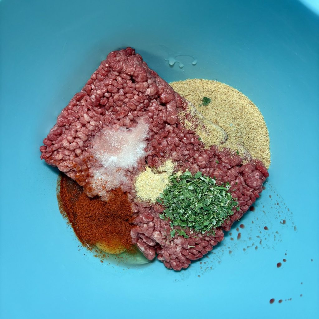 Rohes Hackfleisch mit Gewürzen für Burger Patties in einer Schüssel