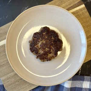 Frisch gebratenes Burger Patty auf einem Teller serviert