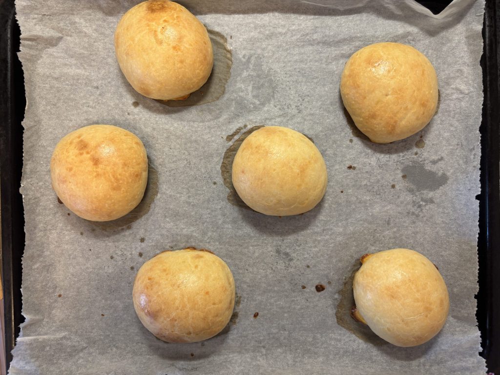 Frisch gebackene Sauerteig Burger Buns auf einem Backblech.