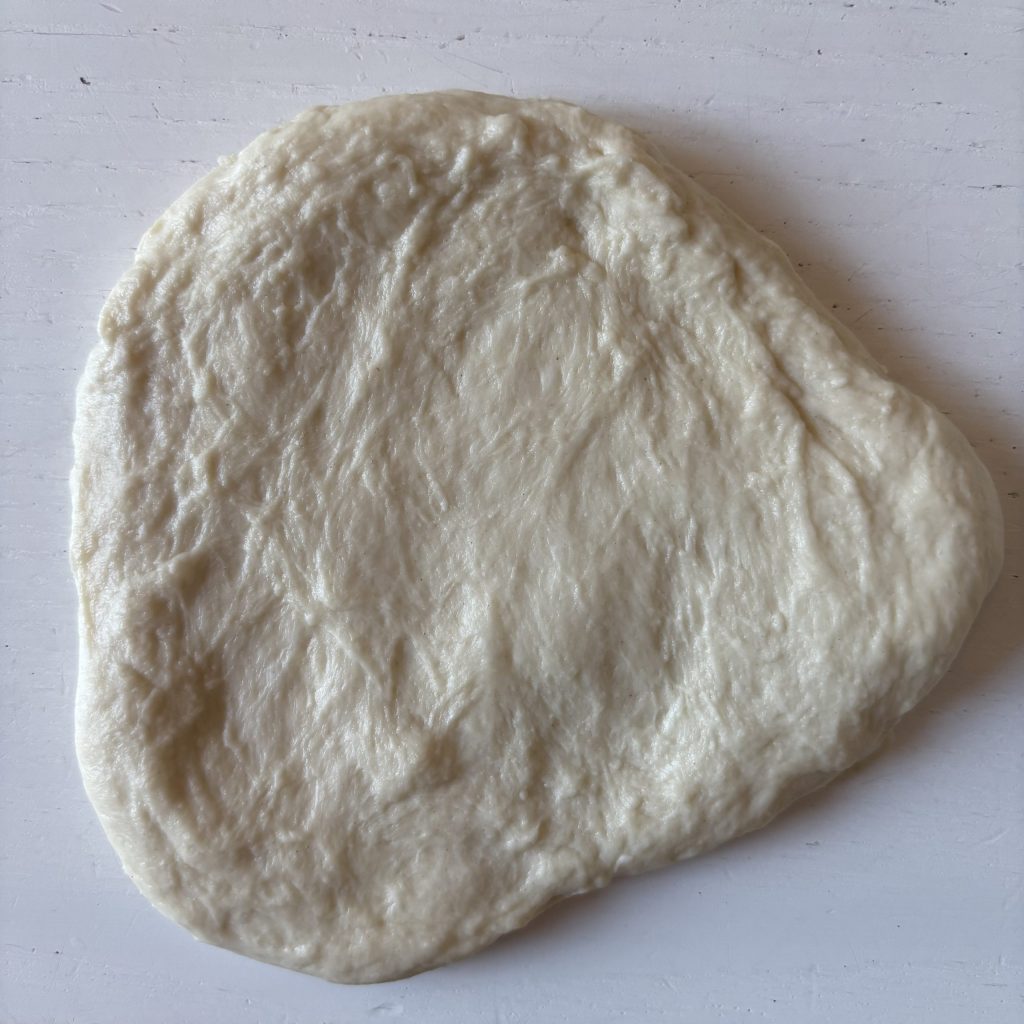 Ausgerollter Sauerteig für Grillbrot auf einer Arbeitsfläche