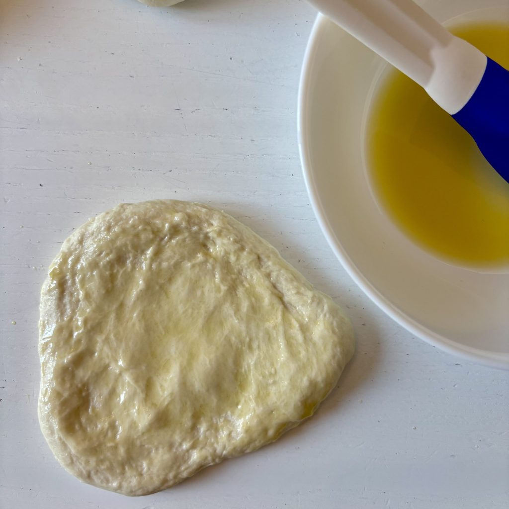 Sauerteig Grillbrot wird vor dem Grillen mit Öl bestrichen