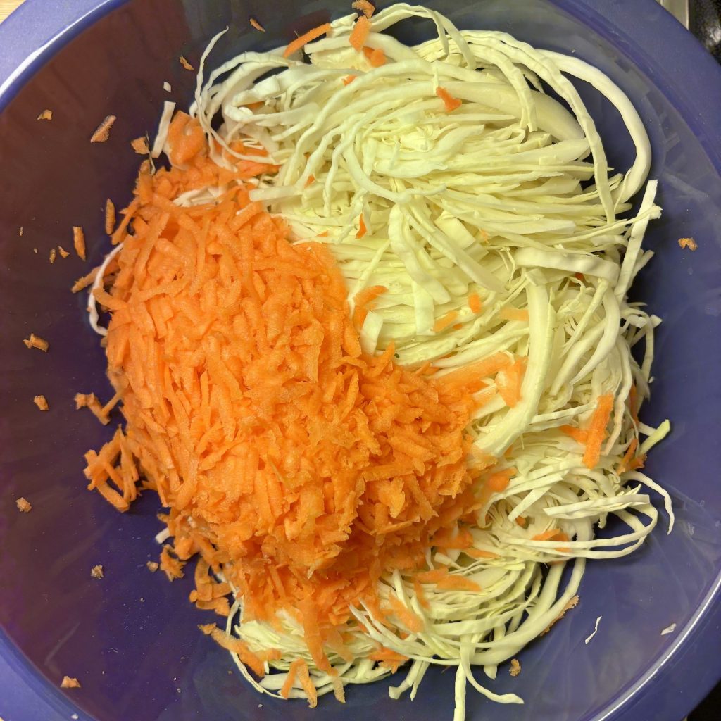 Geraspelte Karotten und fein geschnittener Weisskohl für Coleslaw ohne Mayo