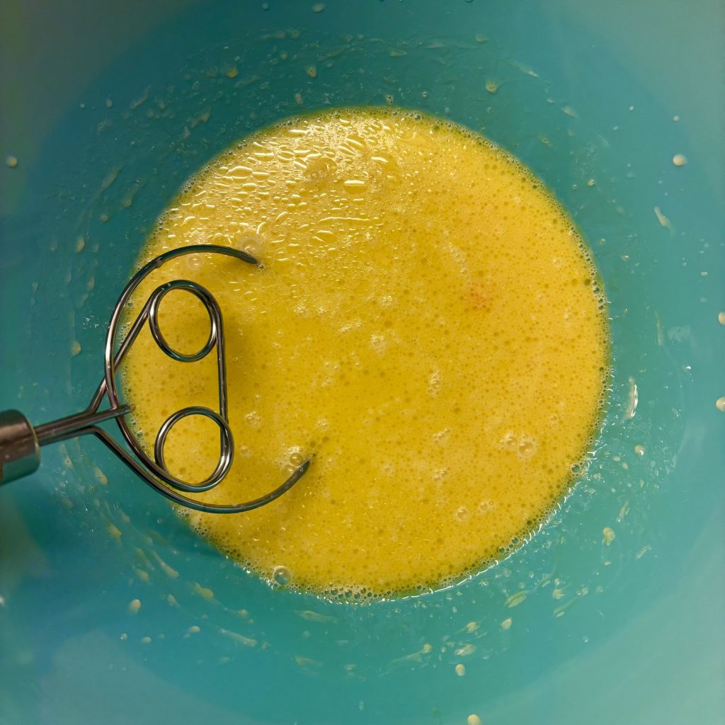Butter oder Öl wird in einer blauen Schüssel für den Sauerteig vermischt