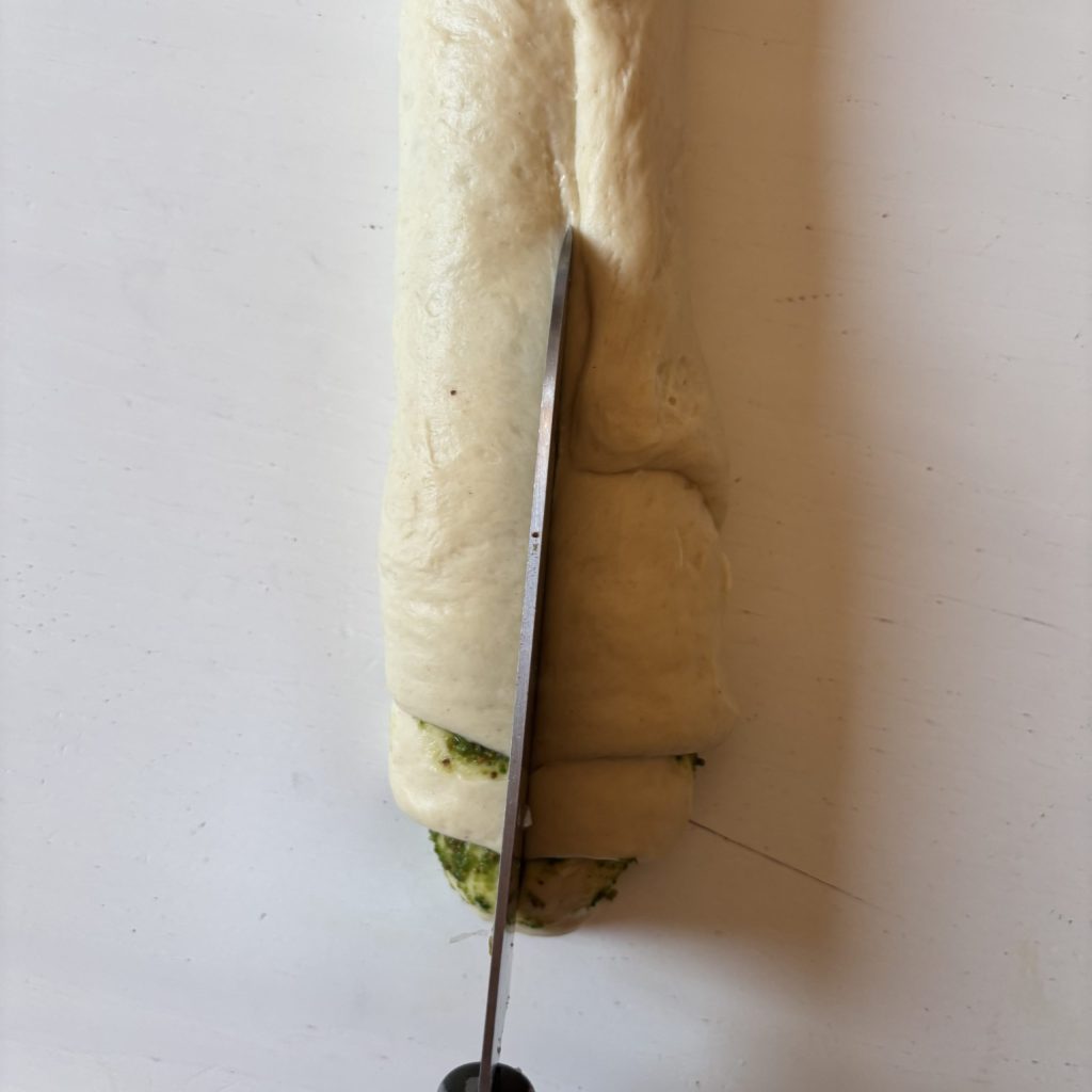 Sauerteig mit Pesto-Füllung wird zu einem Strang aufgerollt