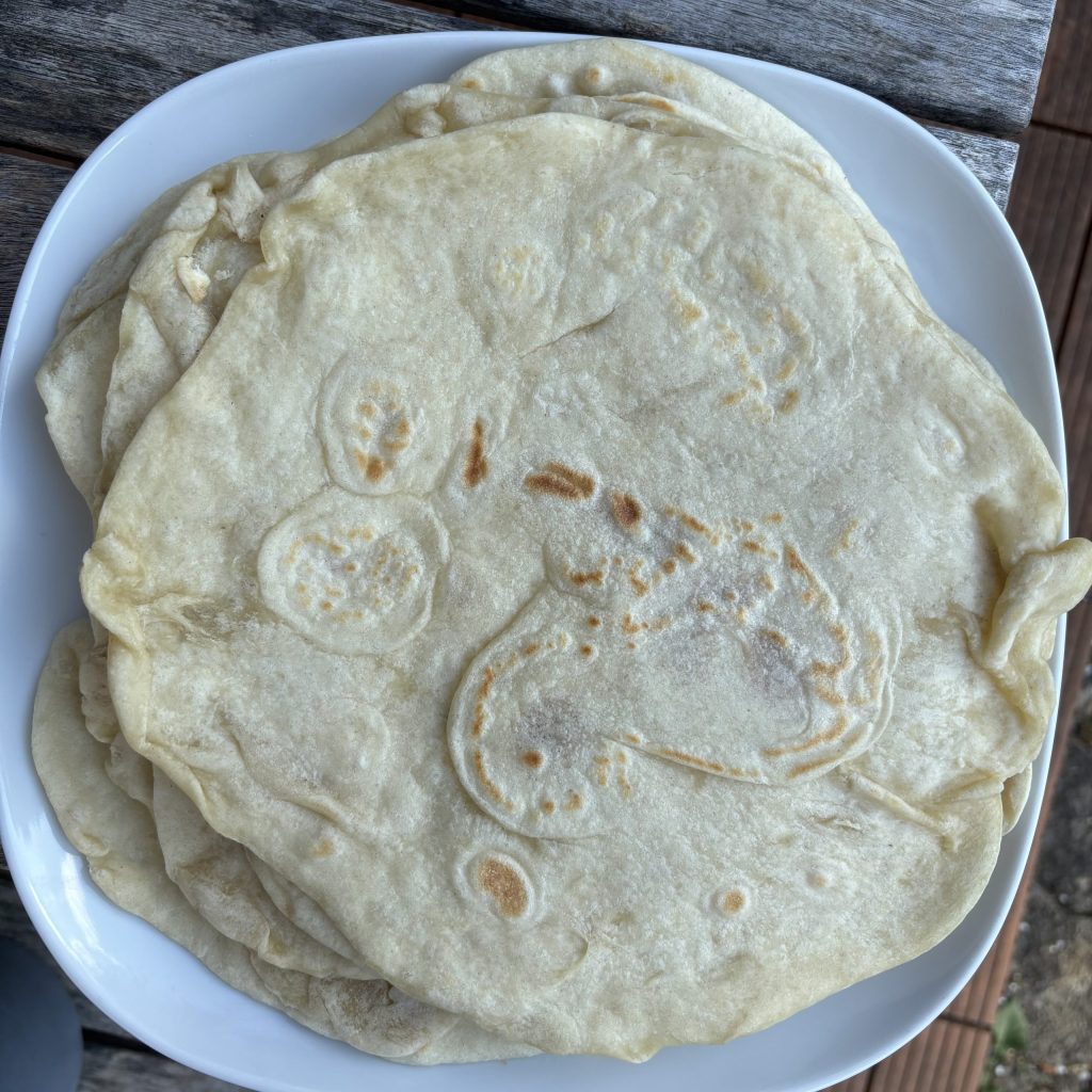 Stapel weiche Sauerteig Tortillas auf einem weissen Teller