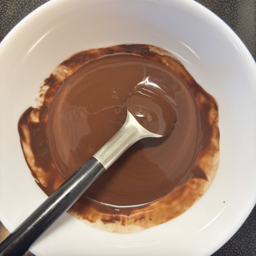 Geschmolzene Schokolade für selbstgemachte Müsliriegel ohne Zucker