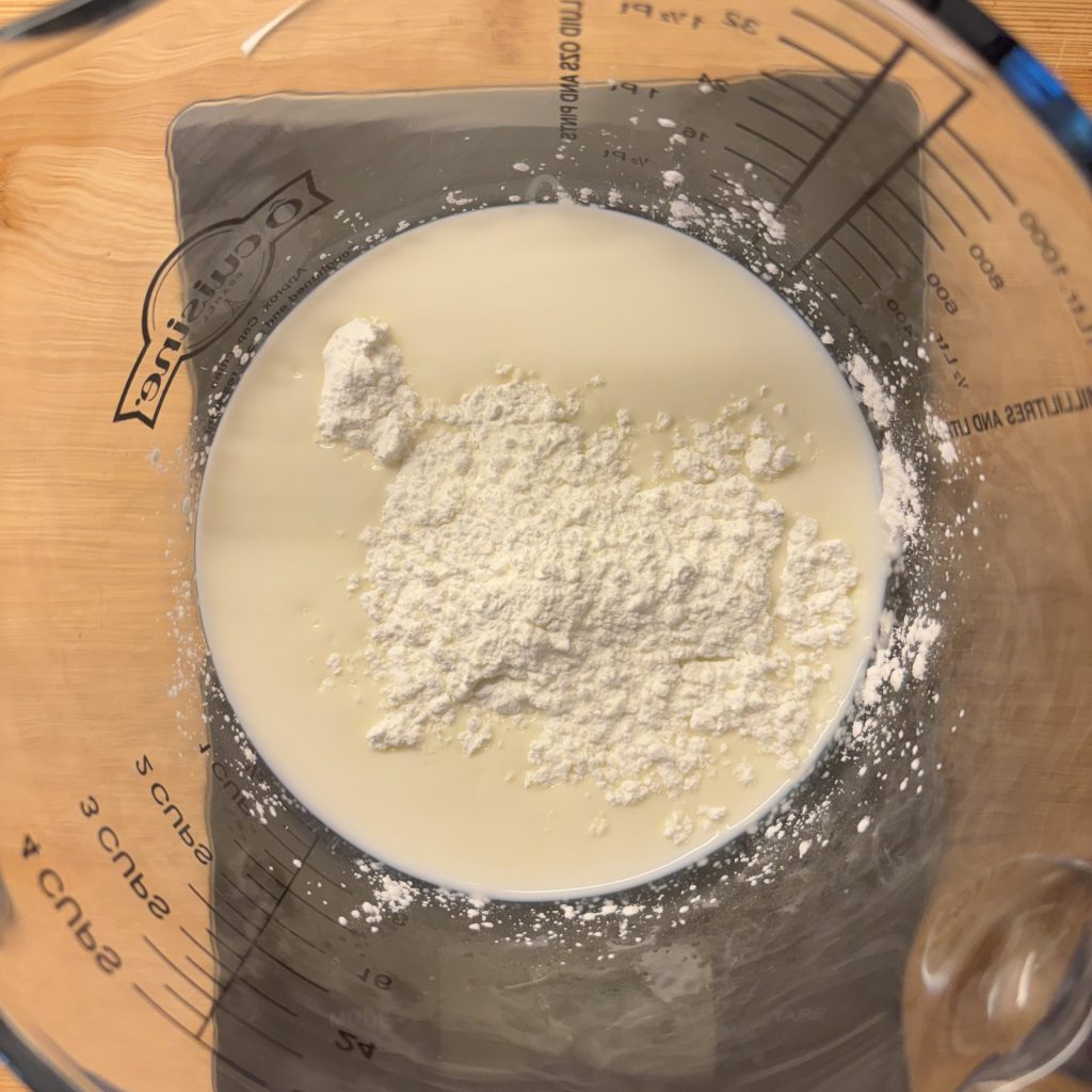Milch und Stärke werden für selbstgemachten Vanillepudding vorbereitet
