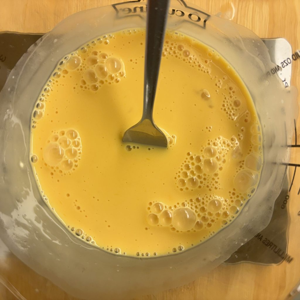 Eigelbe mit Milch für nährstoffreichen Vanillepudding ohne Zucker verrührt