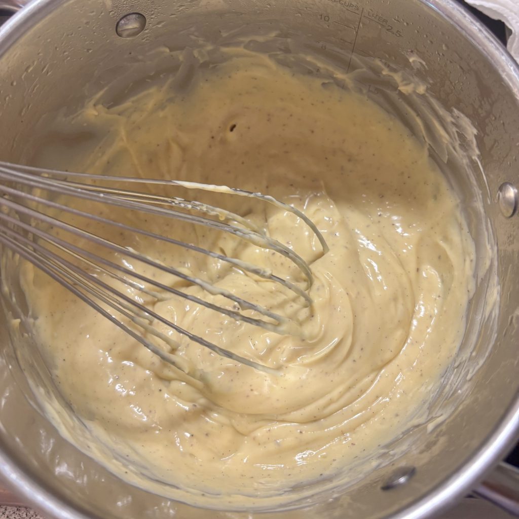 Vanillepudding ohne Zucker wird im Topf mit dem Schneebesen cremig gerührt