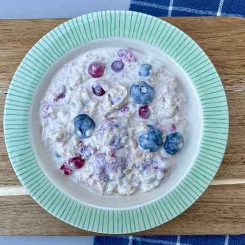 Birchermüsli mit Haferflocken, Apfel und Beeren in einer Schale