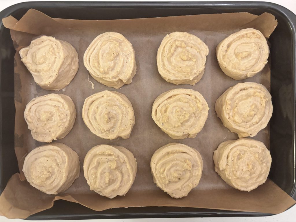 Geformte Puddingschnecken mit Sauerteig auf Backpapier vor der Stückgare