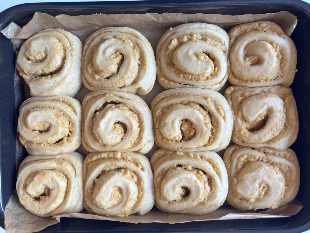 Geformte Frisch gebackene Puddingschnecken mit Sauerteig dicht an dicht in der Backform