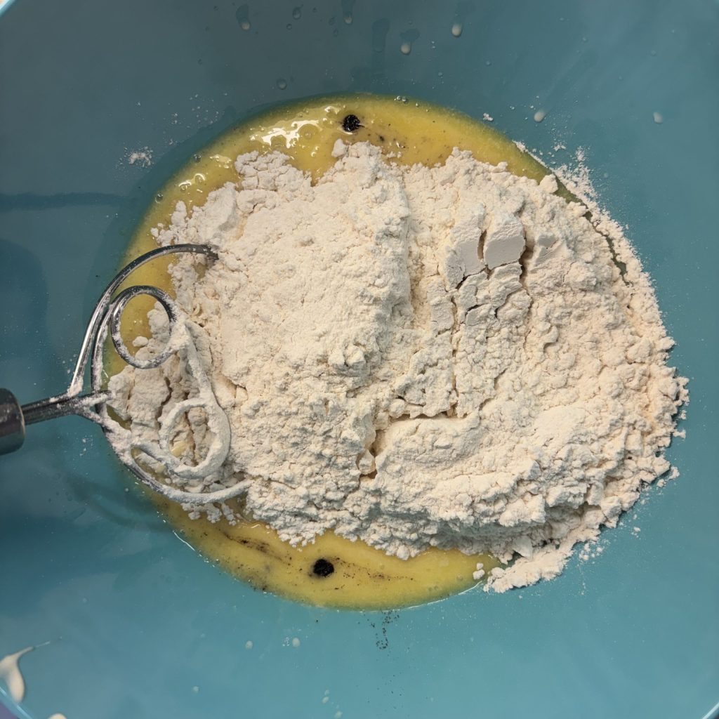 Mehl und flüssige Zutaten für Sauerteig-Rosinenbrötchen