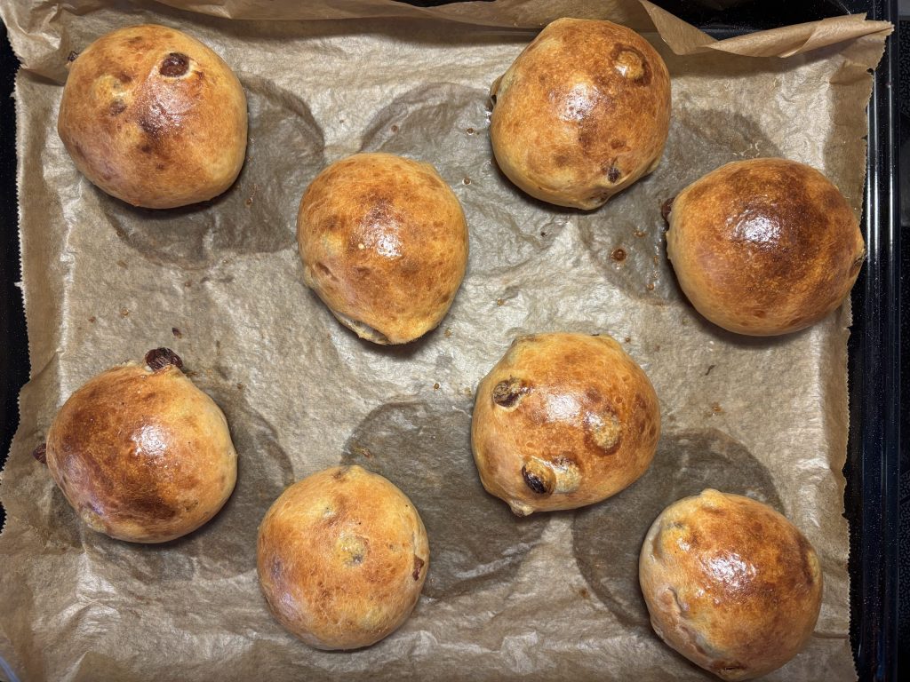 Frisch gebackene Sauerteig-Rosinenbrötchen auf Backpapier