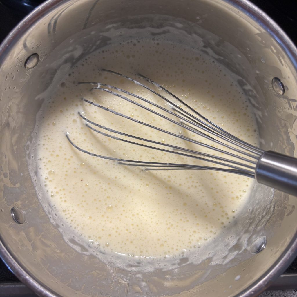 Milchmischung für die Schoggicreme ohne Maizena mit dem Schneebesen verrührt und erwärmt