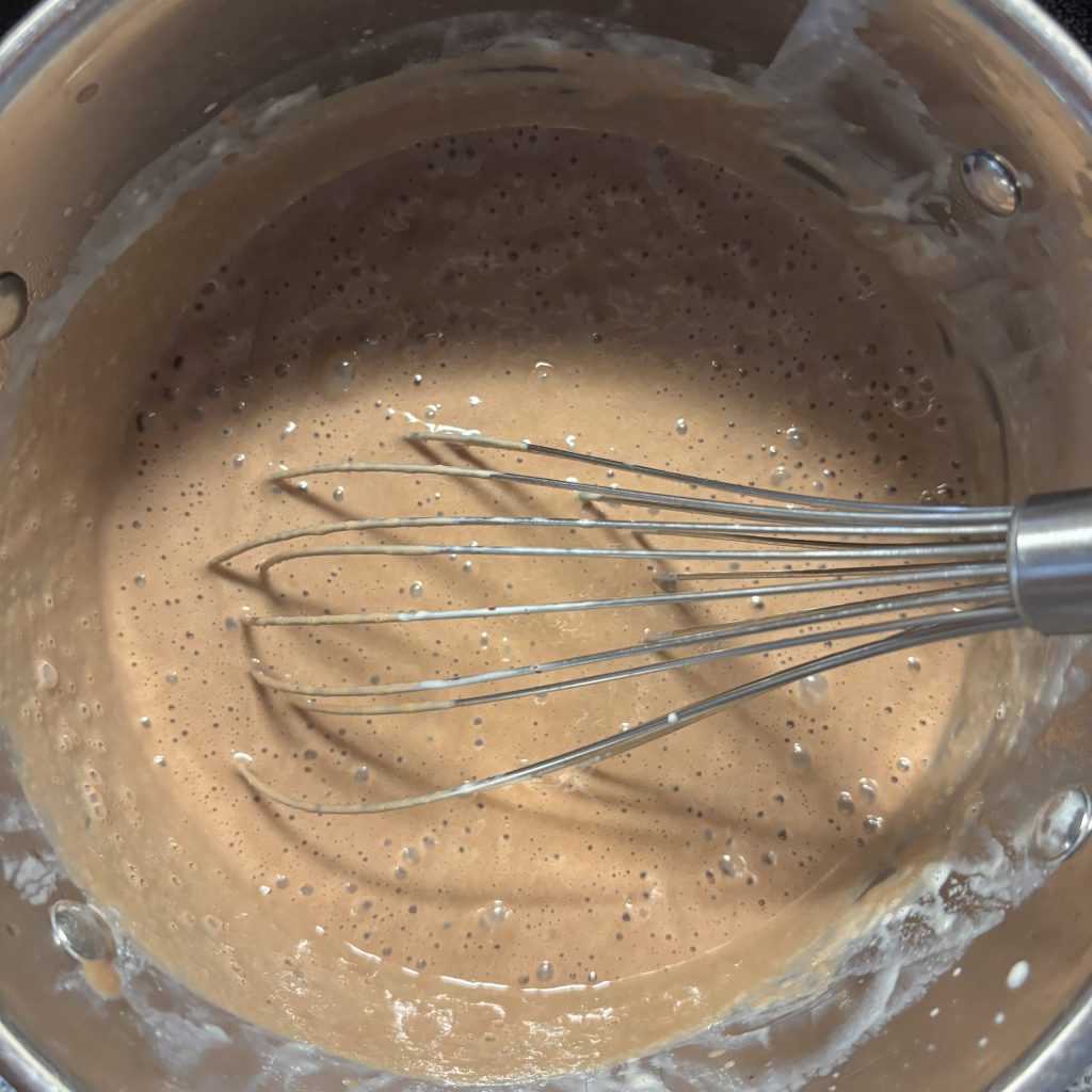 Cremige Eier Milch Mischung mit Schokolade für Schoggicreme ohne Maizena im Topf