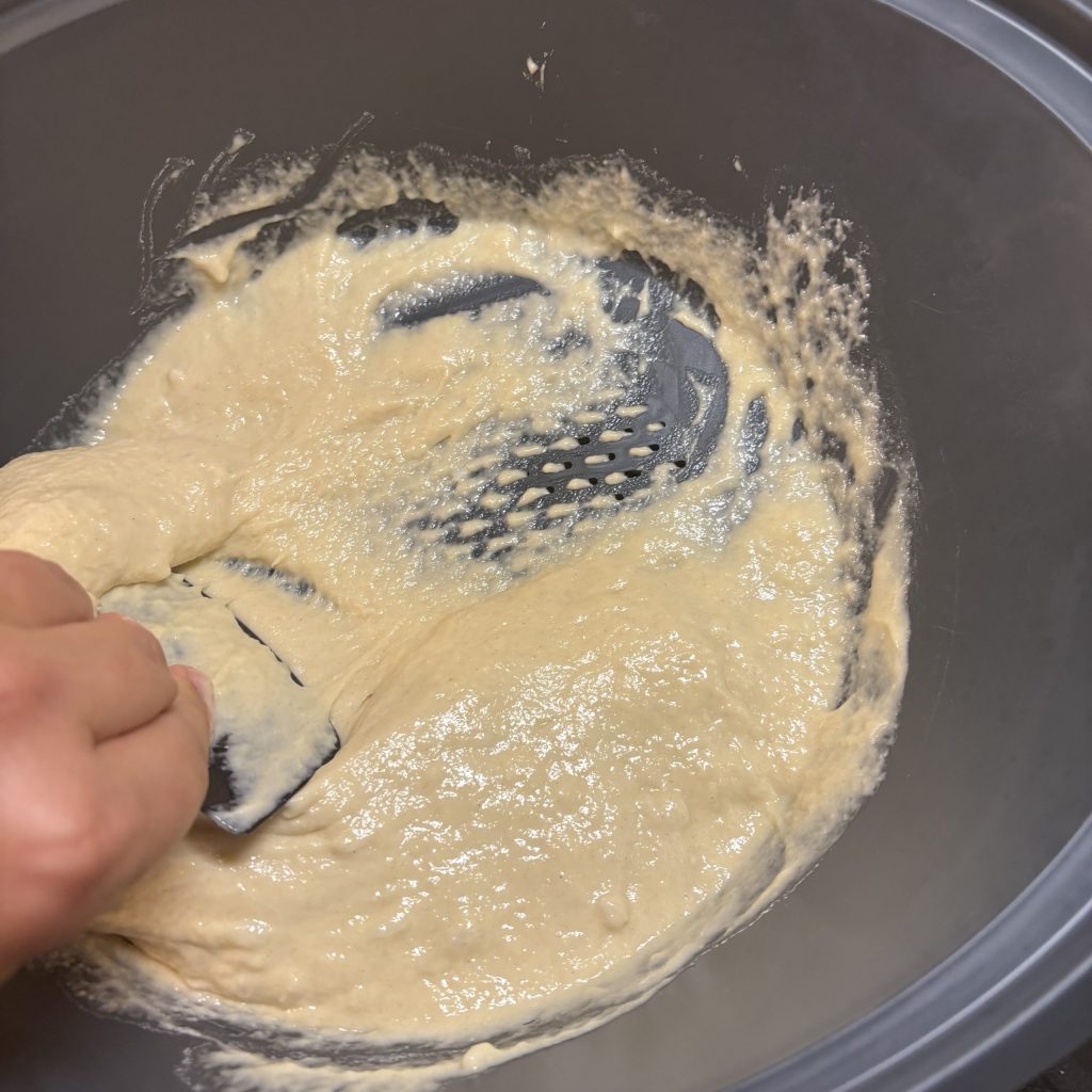 Sauerteig Spätzleteig durch ein Sieb streichen