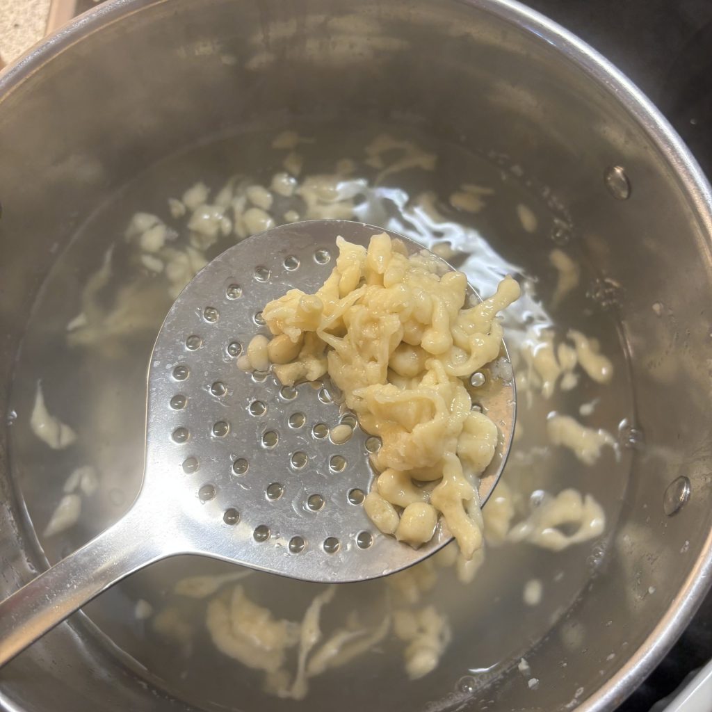 Frisch gekochte Sauerteig Spätzle mit Schaumlöffel
