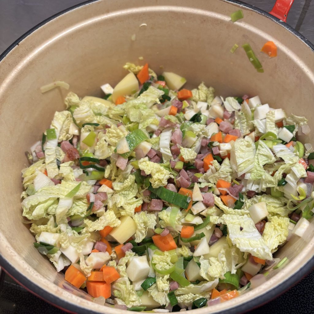 Angebratenes Gemüse und Speck- & Schinkenwürfel für Gerstensuppe.