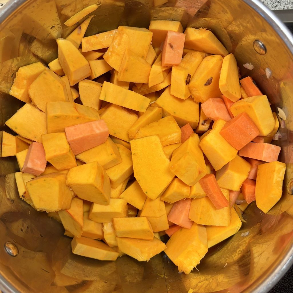 Kürbis und Karotten im Topf für Kürbissuppe