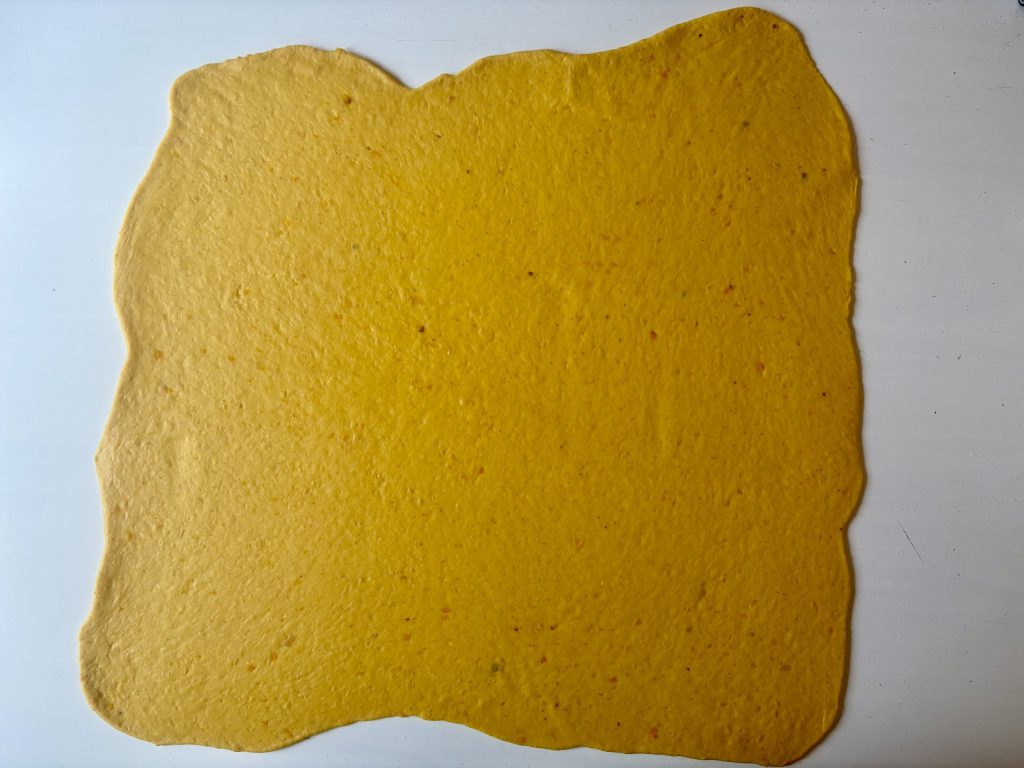 Kürbis-Sauerteig zu einem grossen Rechteck ausgerollt.