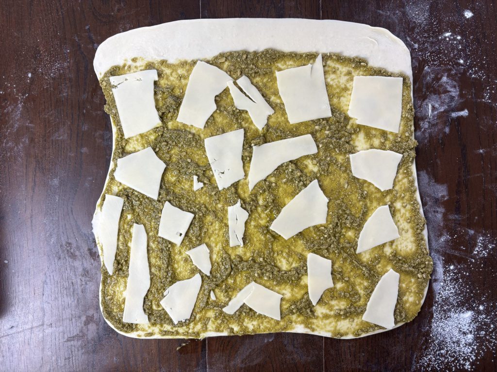 Blätterteig mit grüner Pesto und Käsescheiben belegt
